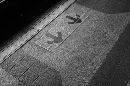 Black arrows on yellow sign background in front of automatic door, exit and entrance on train...