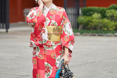 Young girl wearing Japanese kimono standing in front of Sensoji Temple in Tokyo, Japan. Kimono is a Japanese traditional garment. The wordの写真素材