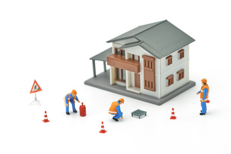 Miniature people Construction worker repair A model house model  using as background real estate concept and repair concept with copy space for your text or design.の写真素材