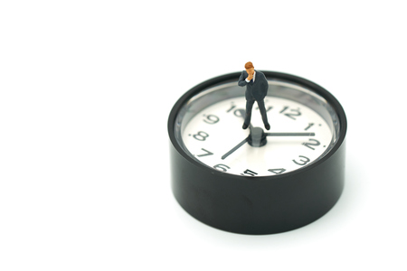 Miniature people businessmen analyze standing on clock as background strategy concept and Business concept with copy space.の写真素材