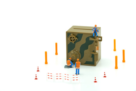 Miniature people Construction worker Security Key Repair And the treatment of the precious. on white...