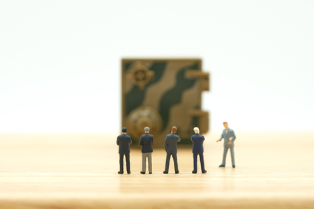 Miniature businessmen standing Investment Analysis Security Key Repair And the treatment of the precious. on white background using as background business concept and Security concept with copy space.の写真素材