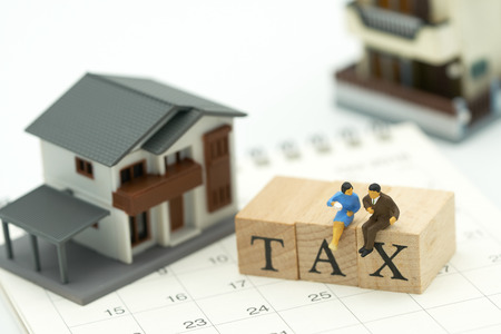 Miniature people Pay Annual income (TAX) for the year on Calendar using as background business concept and finance concept with copy space  for your text or  design.の写真素材