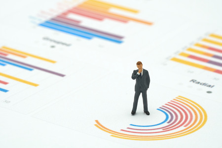 Miniature people businessmen analyze standing on Circle graph with performance as background strategy concept and Business concept with copy space.の写真素材