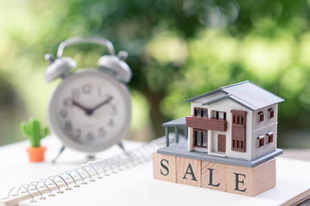 A model house model is placed on wood word sale . as background property real estate concept with copy space for your text or  design.の写真素材