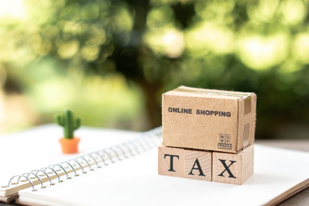 Online shopping box Pay Annual income (TAX) for the year on calculator. using as background business concept and finance concept with copy space  for your text or  design.の写真素材
