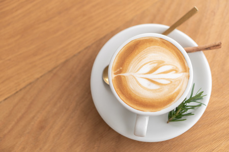 white coffee mug.  Coffee is a latte. table on the wooden table in vintage style, taken from the top view, see the froth of milk foam.の写真素材