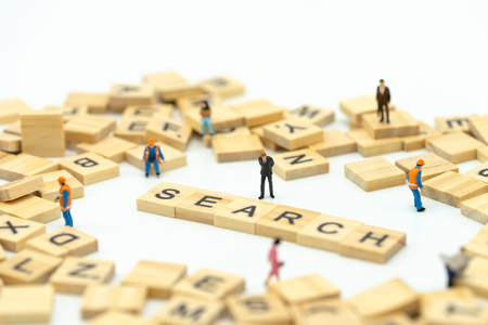 Miniature people businessmen standing with wood word SEARCH. Find something The answer to the solution.using as background business concept and finance concept with copy space  for your textの写真素材