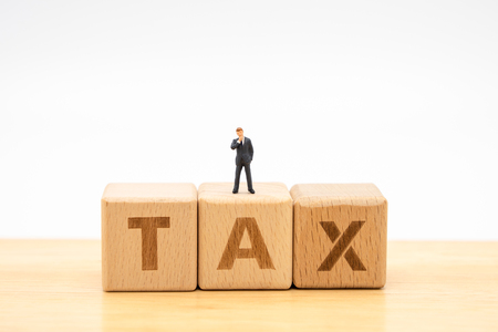 Miniature people businessmen standing with wood word TAX using as background business concept and finance concept with copy space  for your text or  design.の写真素材