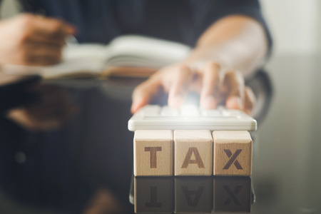 owner Sitting on the annual tax calculation Bracelets from turnover To reduce the tax. using as background business concept and finance concept with copy space  for your text or  design.の写真素材