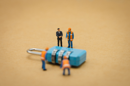 Miniature people Construction worker Security Key Repair And the treatment of the precious. on white background using as background business concept and Security concept with copy space.の写真素材