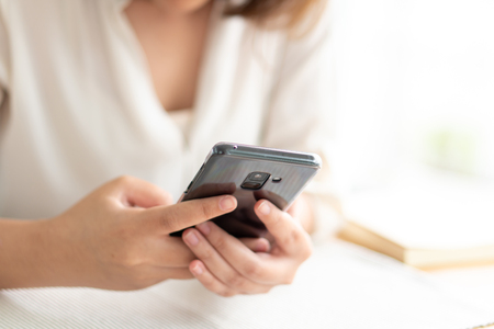 Asian girl Play smartphone For entertainment and work outside the office or outside. Out of Office Concepts Work wirelessly Communication in the modern world.の写真素材