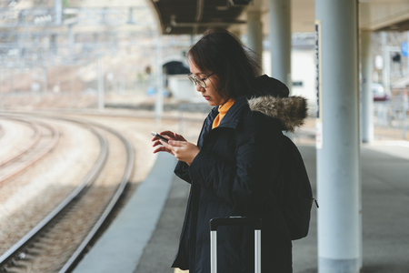 A beautiful Asian woman uses a smartphone in the city center to search for various places. Restaurant reviews And send a message with copy space.の写真素材