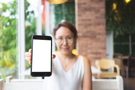 Mockup image of Woman hand holding mobile smartphones isolated white screen for mockup design and...