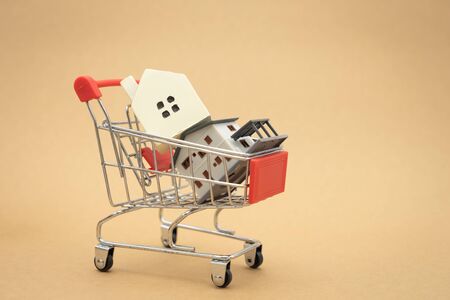 A model house model is placed on a Shopping Cart In the mall.using as background business concept and real estate concept with copy space for your text or design.の写真素材