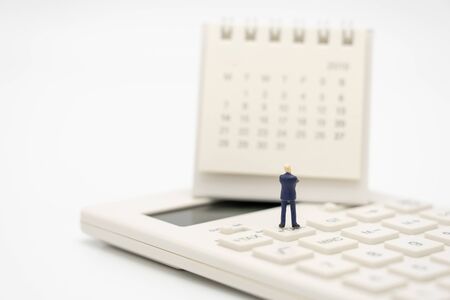 Miniature people Pay queue Annual income (TAX) for the year on calculator. using as background business concept and finance concept with copy space  for your text or  design.の写真素材
