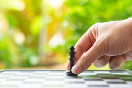 Businessman holding a King Chess is placed on a chessboard.using as background business concept and Strategy concept with copy space for your text or design.の写真素材