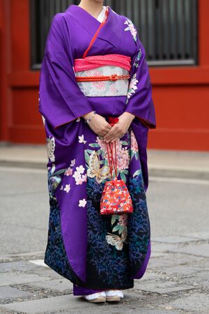 Young girl wearing Japanese kimono standing in front of Sensoji Temple in Tokyo, Japan. Kimono is a Japanese traditional garment.の写真素材