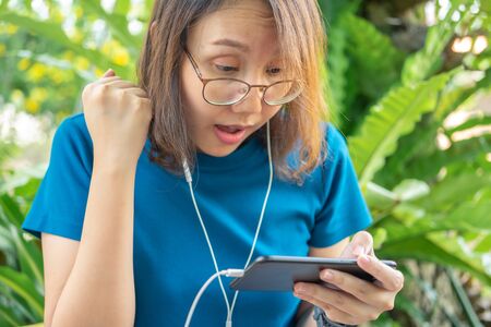 Beautiful women gamers hold their smartphones, play online games or popular esports sports. And is...