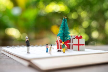 Family Miniature people standing on Christmas tree Celebrate Christmas on December 25 every year....