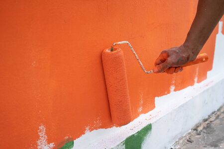 Painter labor Paint the wall using paint plots and rollers. Concepts of work, labor, painting, construction and Labor Dayの写真素材