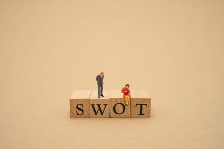 Miniature people businessmen standing with wood word SWOT using as background business concept and finance concept with copy space  for your text or  design.の写真素材