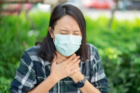 Woman wearing face mask protect filter against air pollution (PM2.5) or wear N95 mask. protect pollution, anti smog and viruses, Air pollution caused health problem. environmental pollution concept.の写真素材