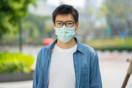 HandsomeMan wearing face mask protect filter against air pollution (PM2.5) or wear N95 mask. protect pollution, anti smog and viruses, Air pollution caused health problem. Global warming concept.の写真素材