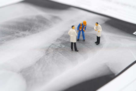 Miniature people Doctor and Construction worker on Lung x-ray To check for Covid 19 viruses or coronavirus .using as background Healthcare concept and Medical concept with copy space.の写真素材
