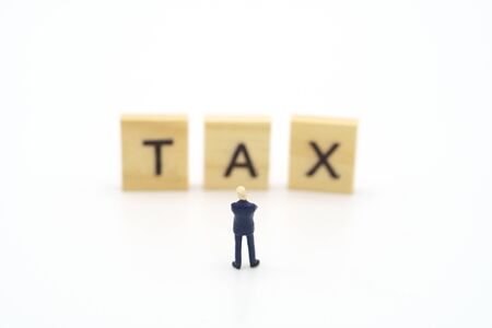 Miniature people Pay queue Annual income (TAX) for the year on calculator. using as background business concept and finance concept with copy space  for your text or  design.の写真素材