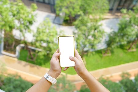 Mockup image of Woman hand holding mobile smartphones isolated white screen for mockup design and others app display background. Graphic design montageの写真素材