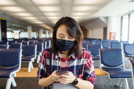 woman wearing face mask is traveling on The airport , New lifestyle travel after covid-19. Social...