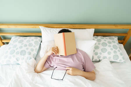 Asian handsome man Read books while sleeping. Man book cover Drowsiness causes sleep.The concept of...