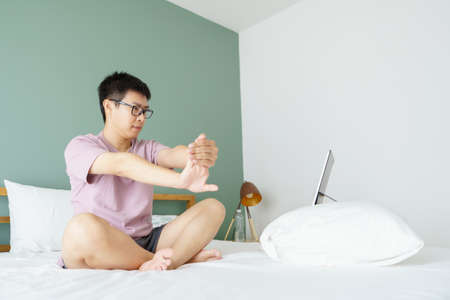 New normal Training At Home An Asian man, aged 35-40, with brown skin, Home exercise. exercising in...