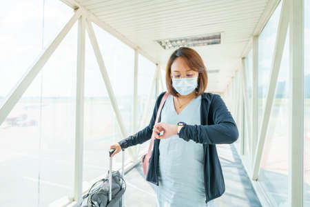 woman wearing face mask is traveling on The airport , New lifestyle travel after covid-19. Social distancing and Travel bubble concept.の写真素材