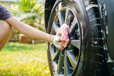 Female hand hold microfiber cloth for washing car. Concept disinfection and antiseptic cleaning of the vehicleの写真素材