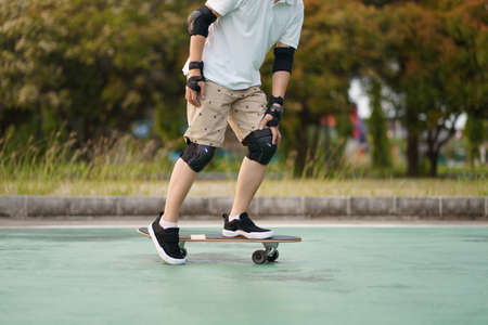 Asian having fun with surfboards or surf skate around city streets background on a summer day. Free relax lifestyle and millennial trend conceptの写真素材