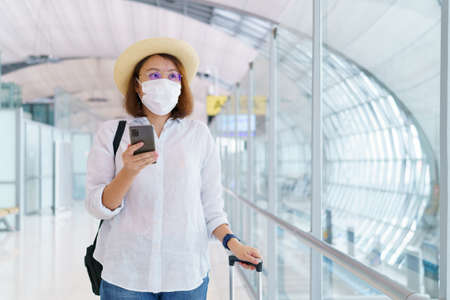 New Normal tourist wearing face mask is traveling on The airport . Social distancing healthcare system ,stay safe and Travel bubble concept.の写真素材