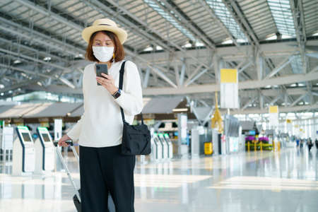 New Normal tourist wearing face mask is traveling on The airport , New lifestyle travel . Social distancing healthcare system ,stay safe and Travel bubble concept.の写真素材