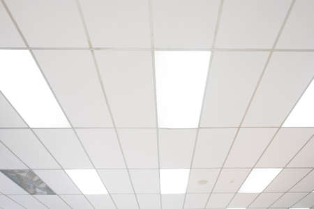 White ceiling with neon light bulbs in uprisen view.as background interior decoration concept with...