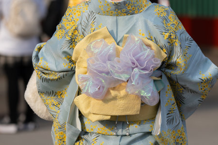 Young girl wearing Japanese kimono standing in front of Sensoji Temple in Tokyo, Japan. Kimono is a...