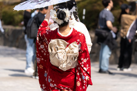 Traditional girl in kimono with umbrella on the streetの写真素材