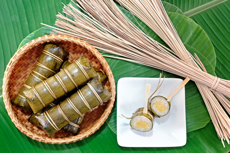 Glutinous rice steamed in banana leaf in bamboo bowl.の写真素材
