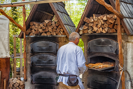 Nuembrecht, Germany - April 30, 2017: Baker on a medieval market, takes bread out of an oven.のeditorial素材