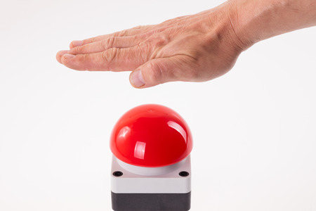 Hand pushing a red buzzer isolated on white