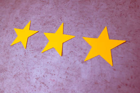 Customer Experience Concept. Three yellow stars on purple concrete background. Negative feedback