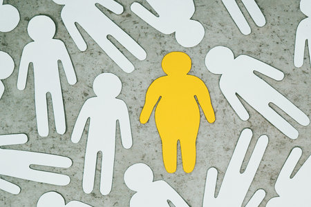 An overweight person among ordinary people. Paper-cut silhouettes. Nutrition and weight control, health care.の写真素材