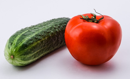 Isolated red tomato and green cucumber on a white backgroundの写真素材