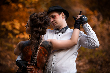 Young man imitating music performance on woman's back with painted violinの写真素材