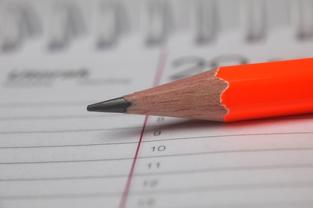 Pencil laying on spiral notebook or notepad with lined paper.の写真素材